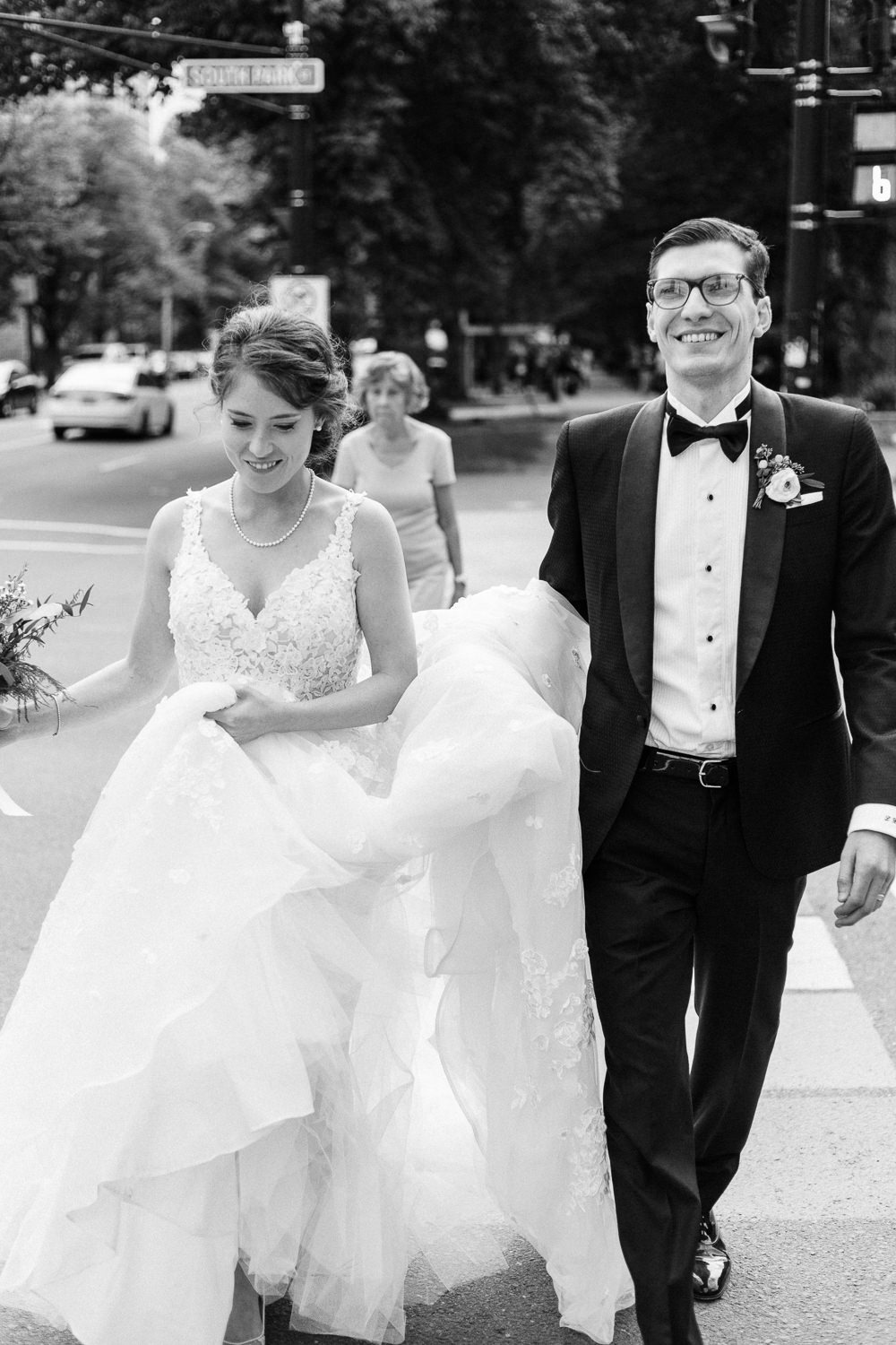 bride and groom crossing street to enter wedding reception
