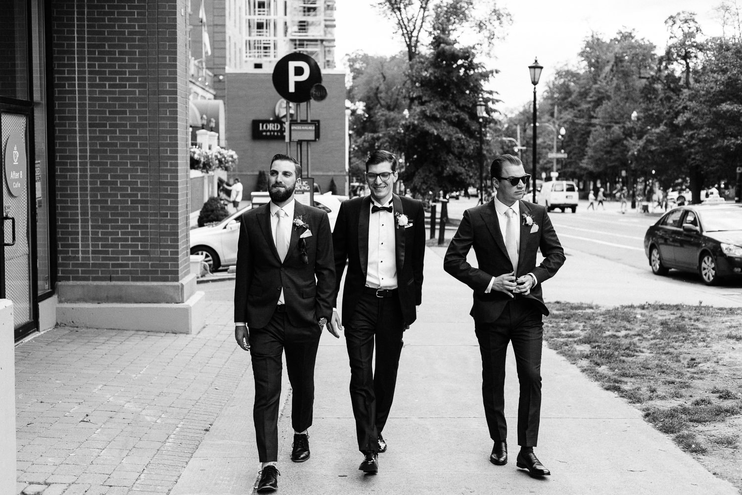 groom and groomsmen walking outside lord nelson hotel