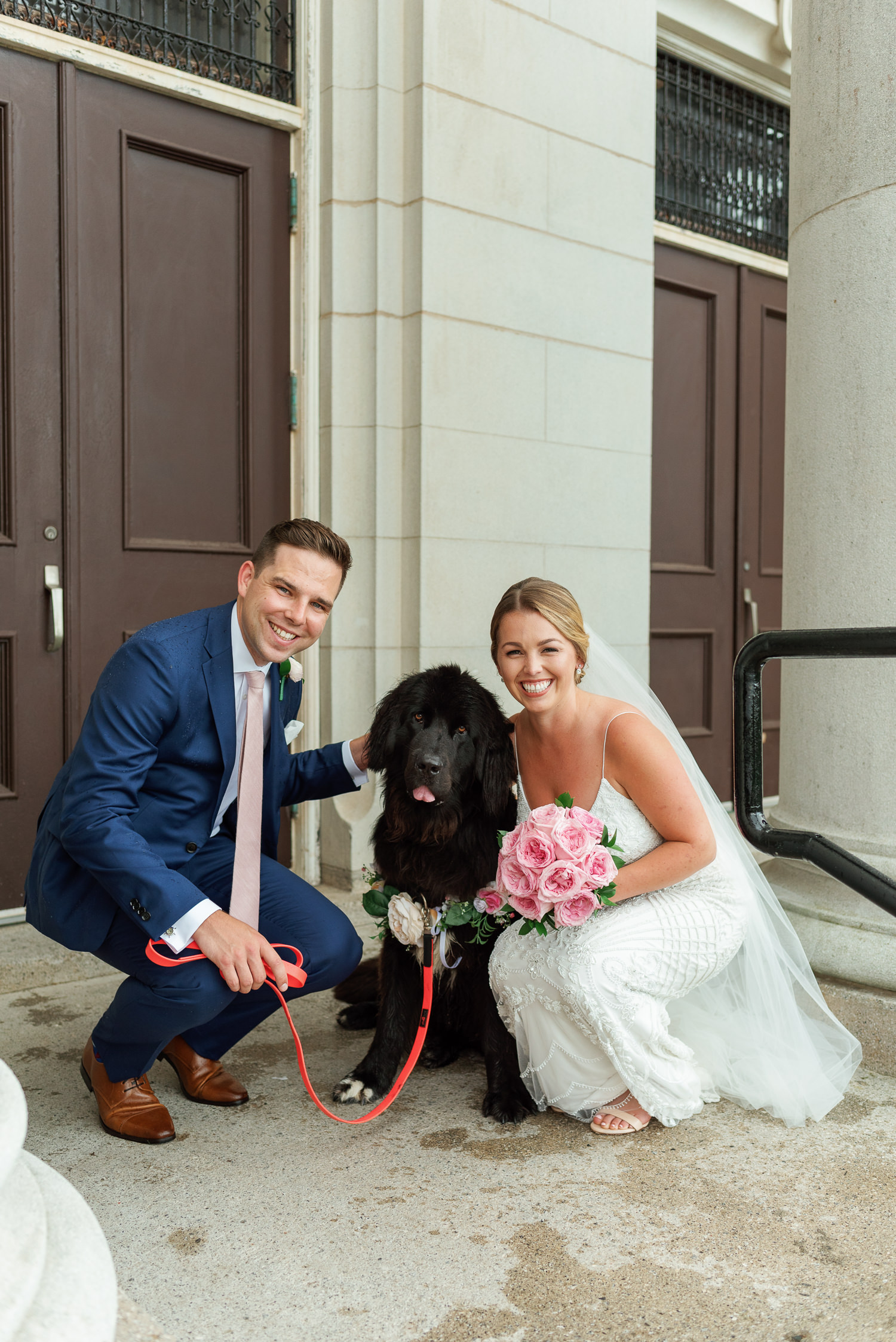 bride and groom pose with their dog outside acadia university