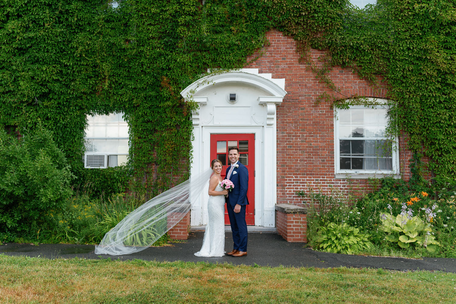 bride and groom pose for photo outside at acadia university