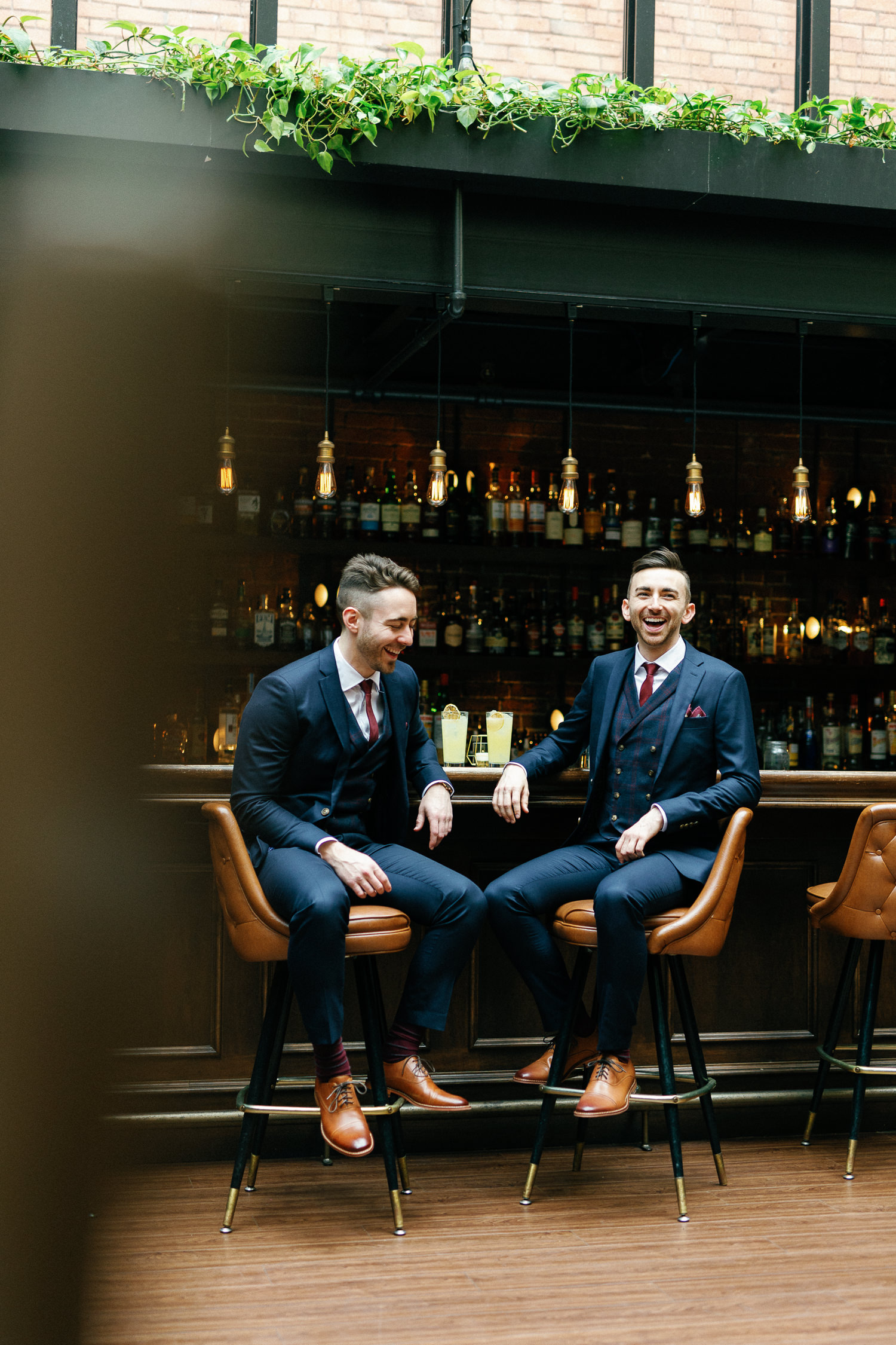 grooms pose for portraits at the bar