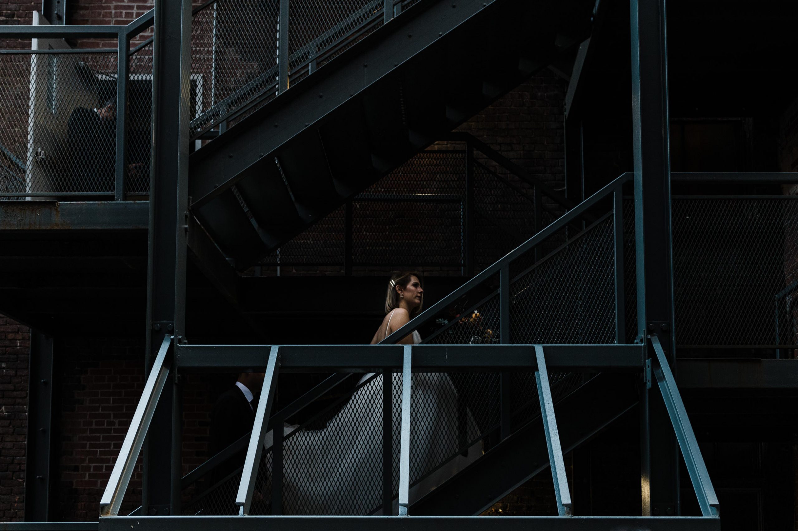 bride walks up fire escape staircase