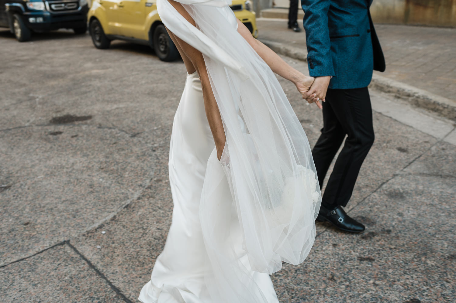 Bride and groom cross quiet street in downtown Halifax