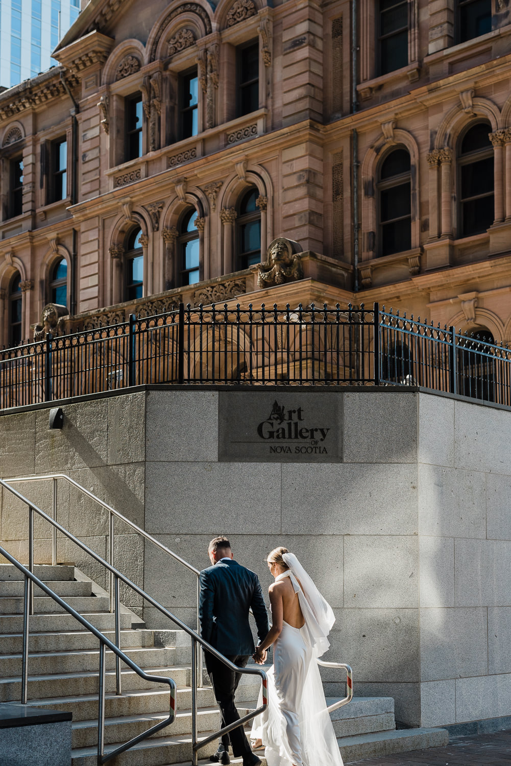 Wedding couple walking up steps at the Art Gallery of Nova Scotia