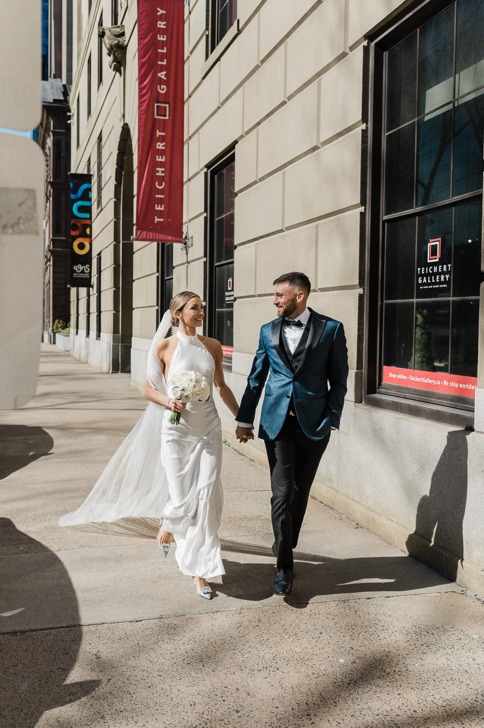 Stylish wedding couple walk along Hollis Street in Halifax