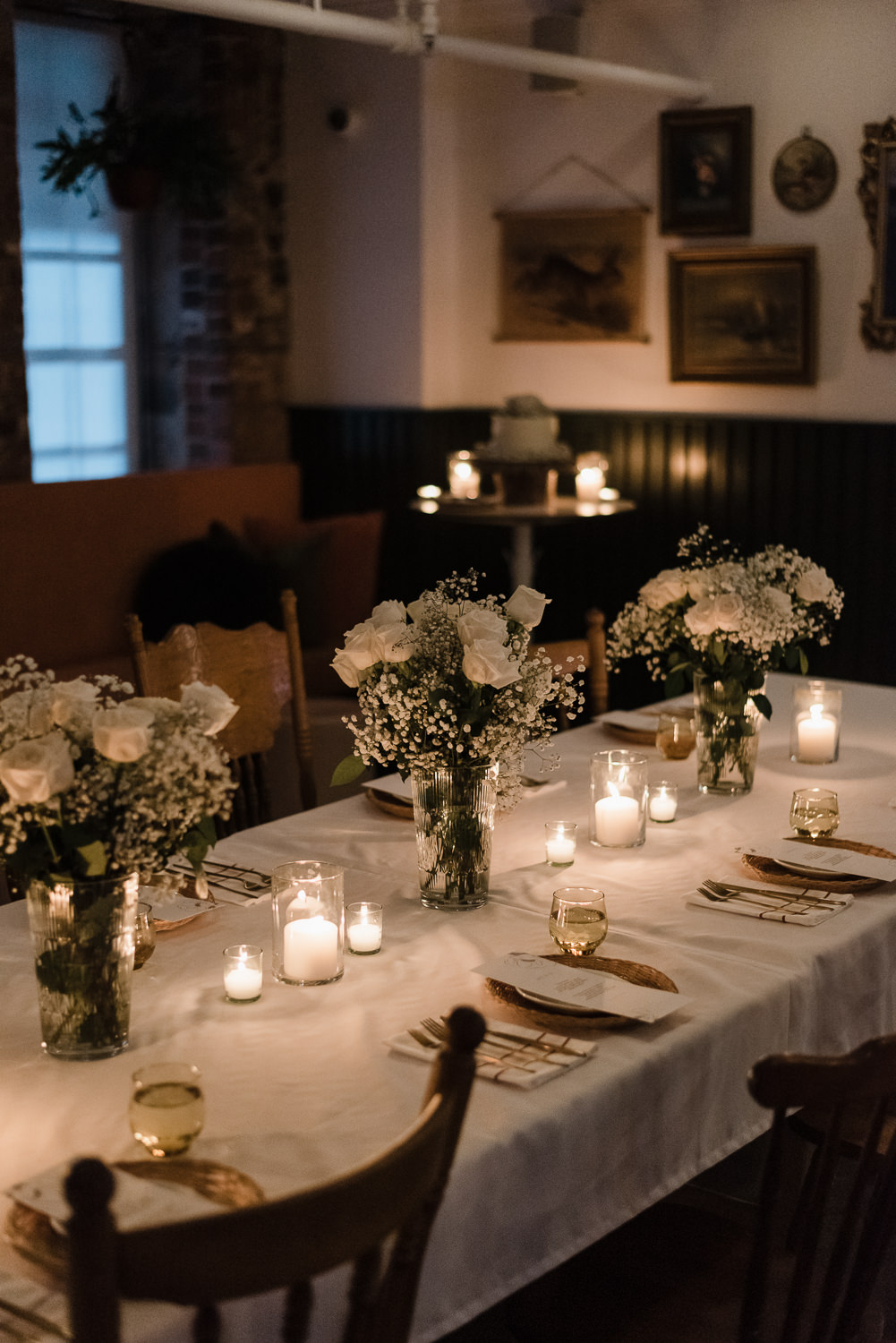 Candlelit table with dinner place settings and flowers at Anemone dining