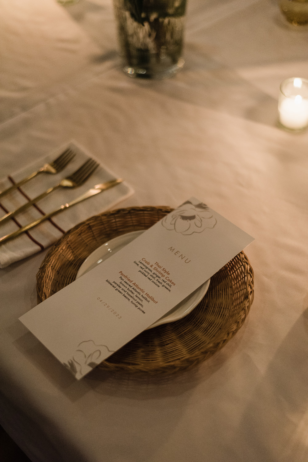 Candlelit table with dinner place settings and flowers at Anemone dining