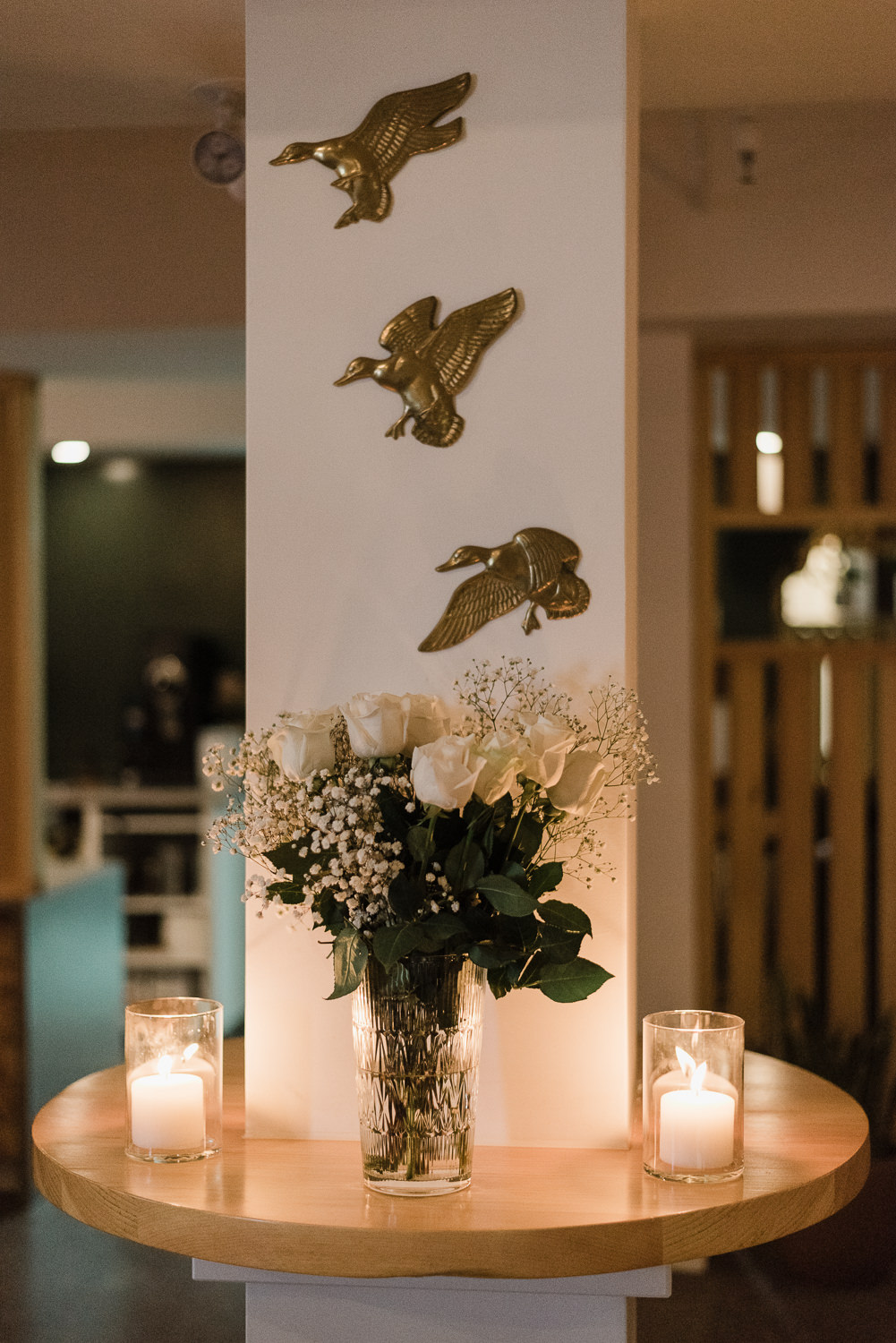 Table with flowers and candle at cozy Anemone Dining wedding