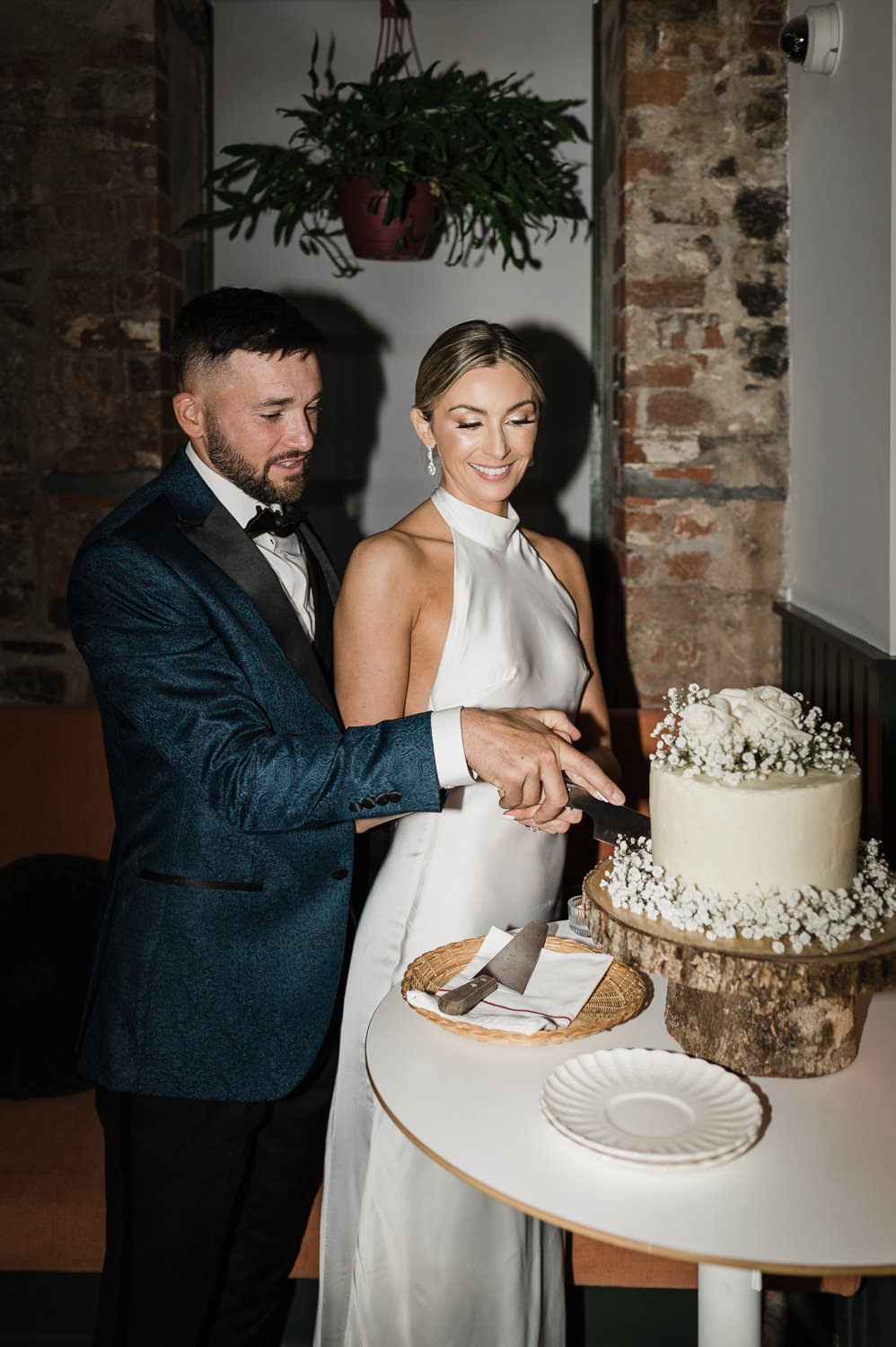 Flash photography of stylish bride and groom cutting cake at Anemone Dining.