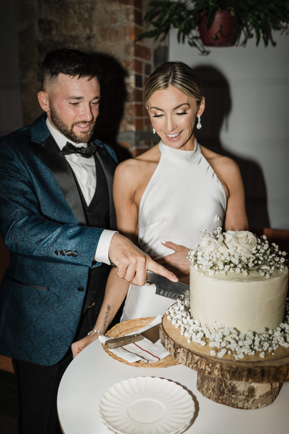 Flash photography of stylish bride and groom cutting cake at Anemone Dining.