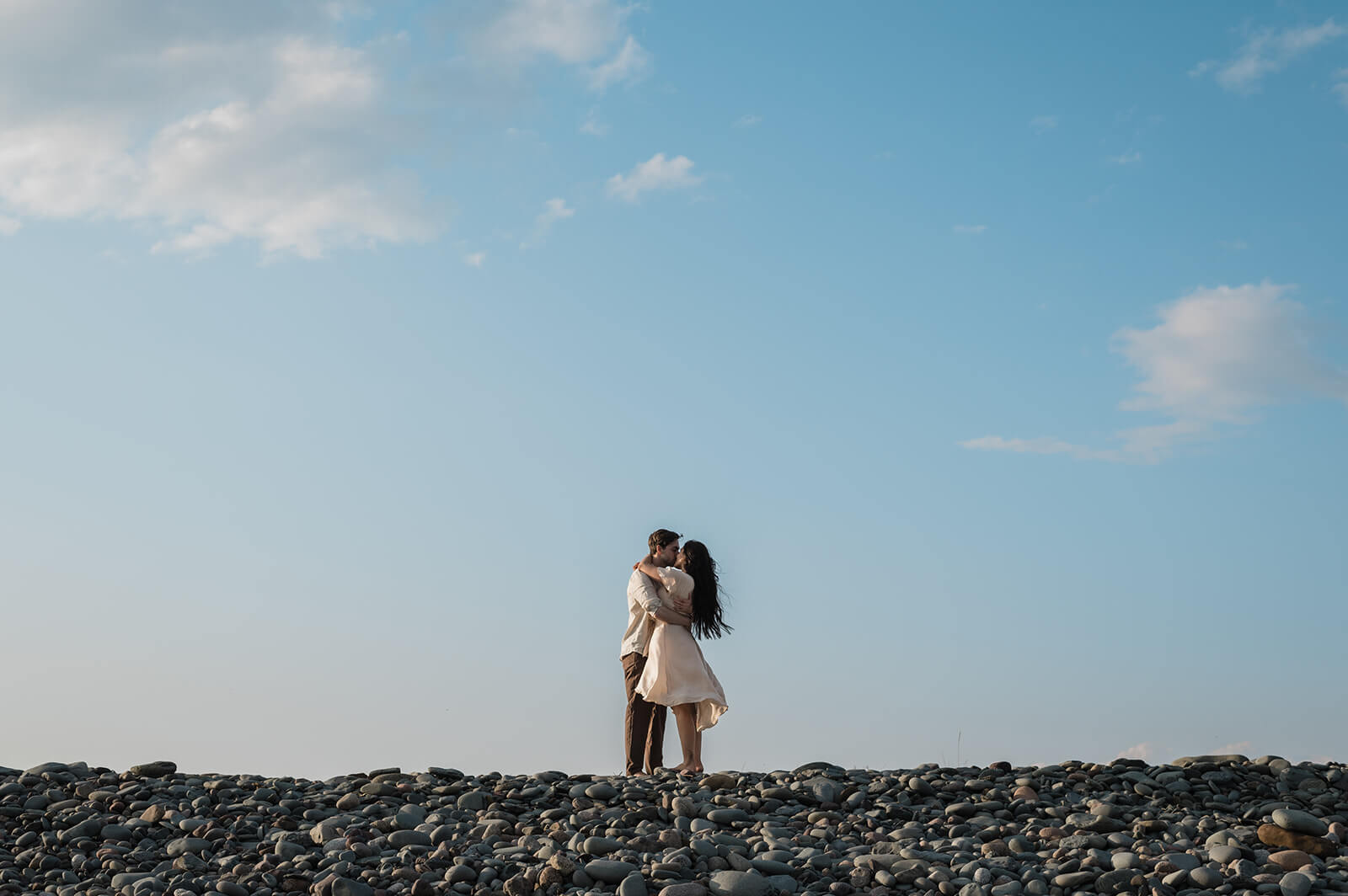 couple embrace at beach engagement session