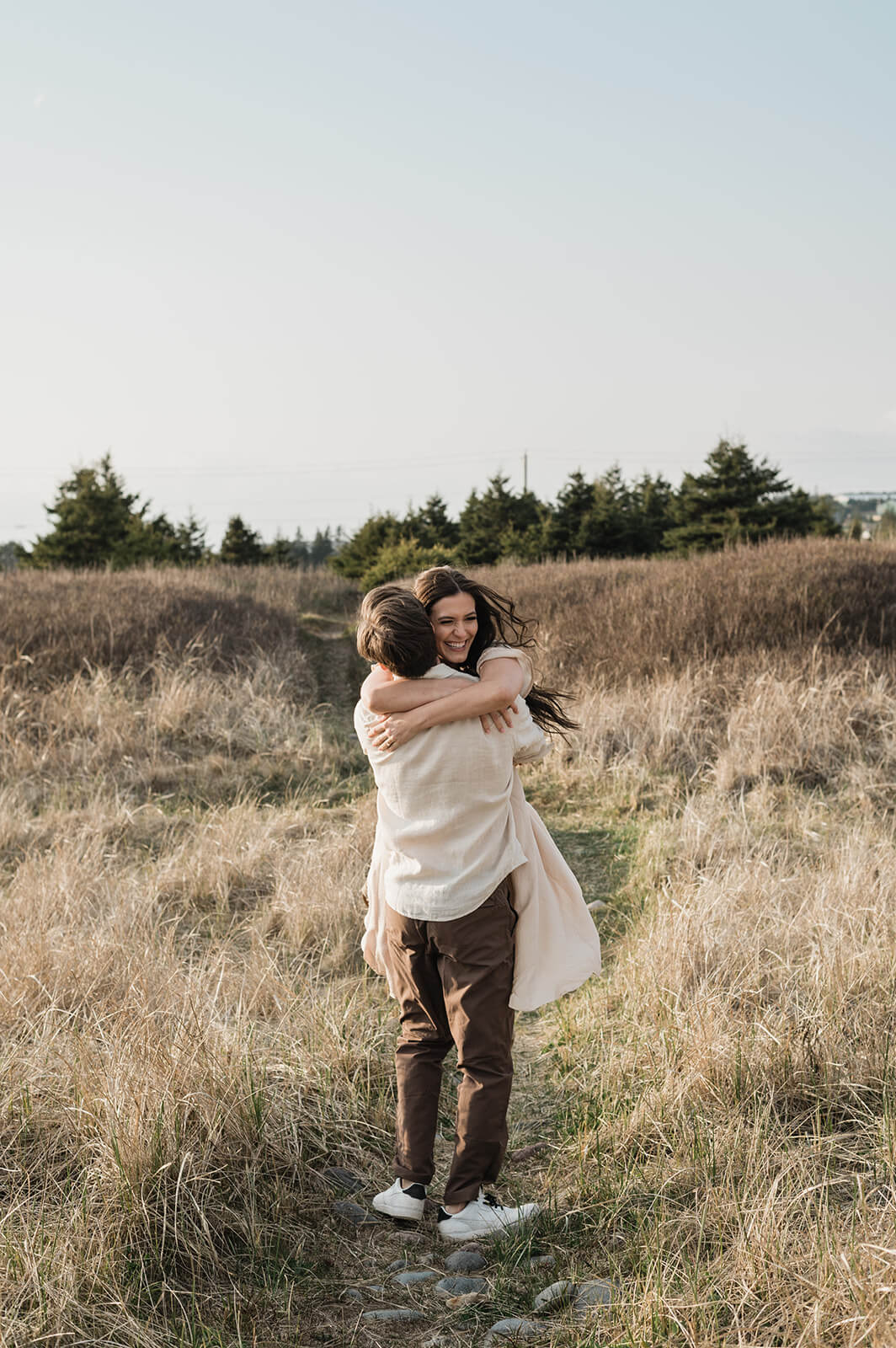 couple embrace at beach engagement session