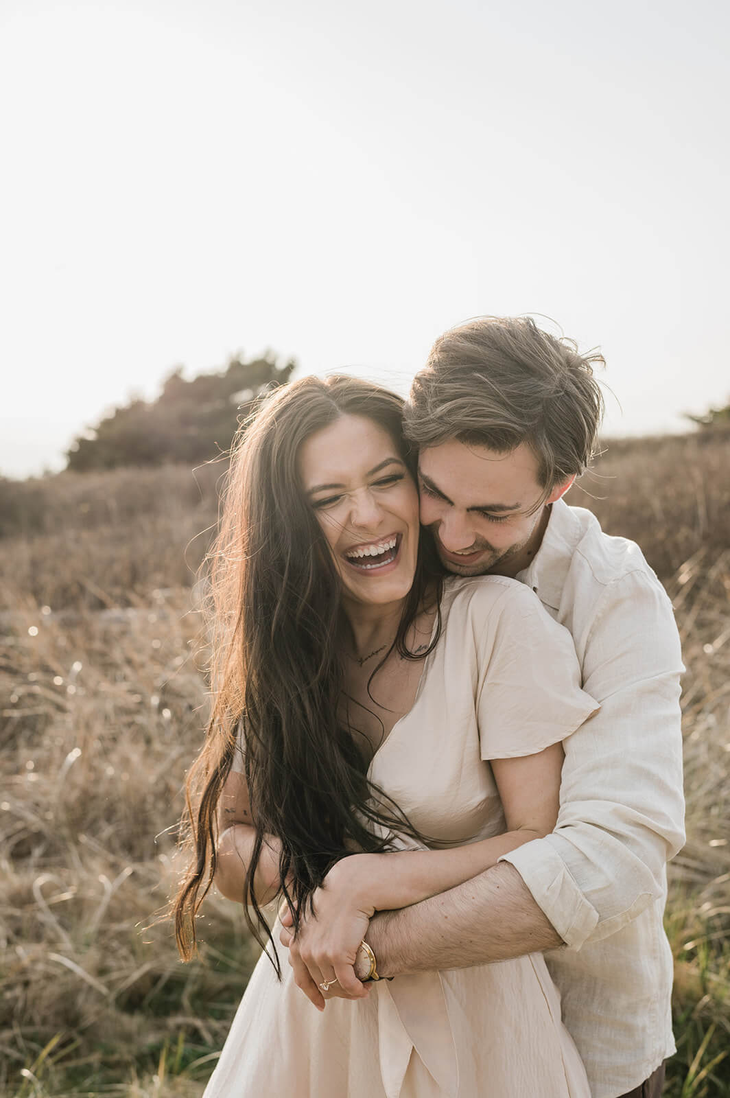 couple embrace at beach engagement session