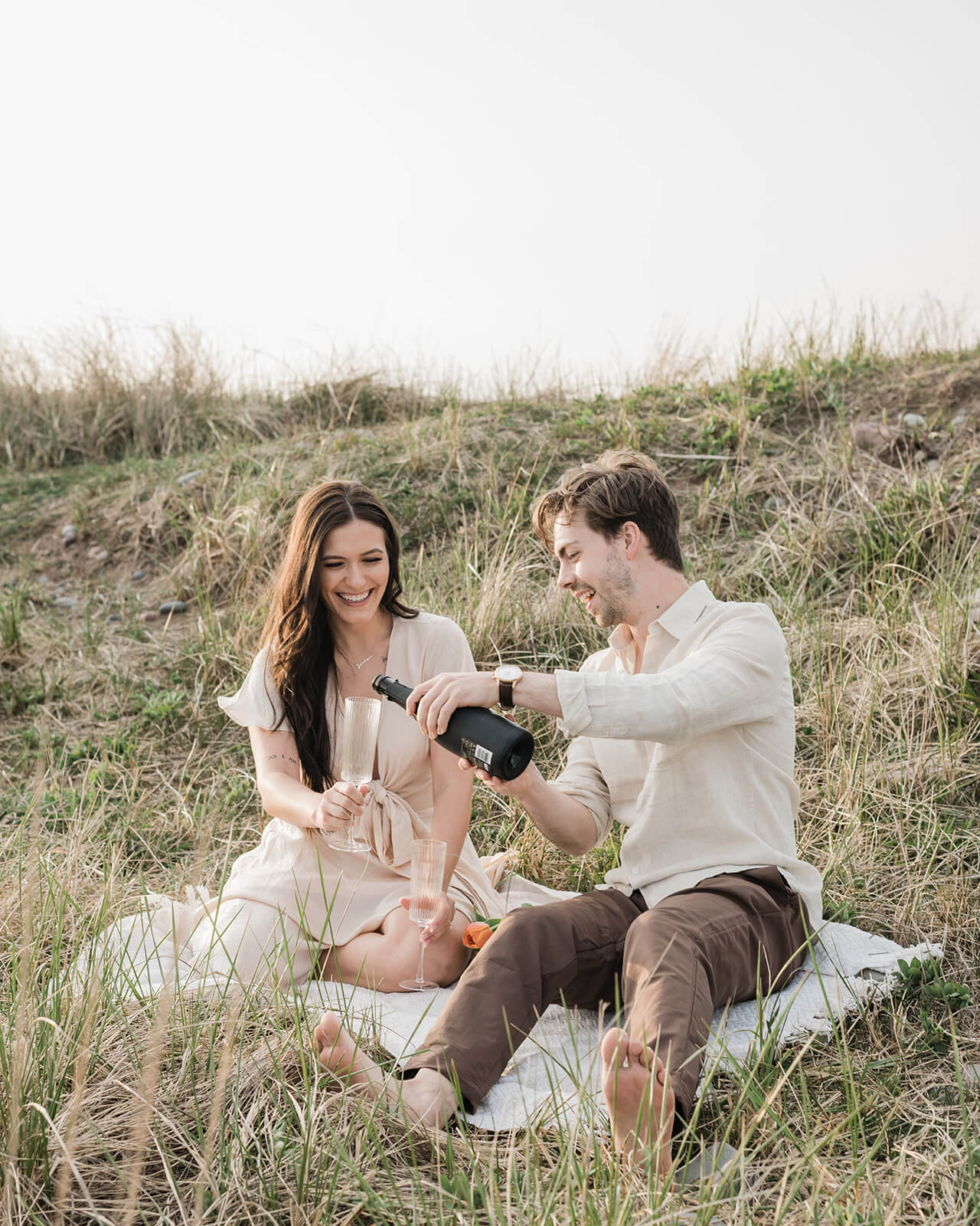 champagne shared between couple at beach engagement session