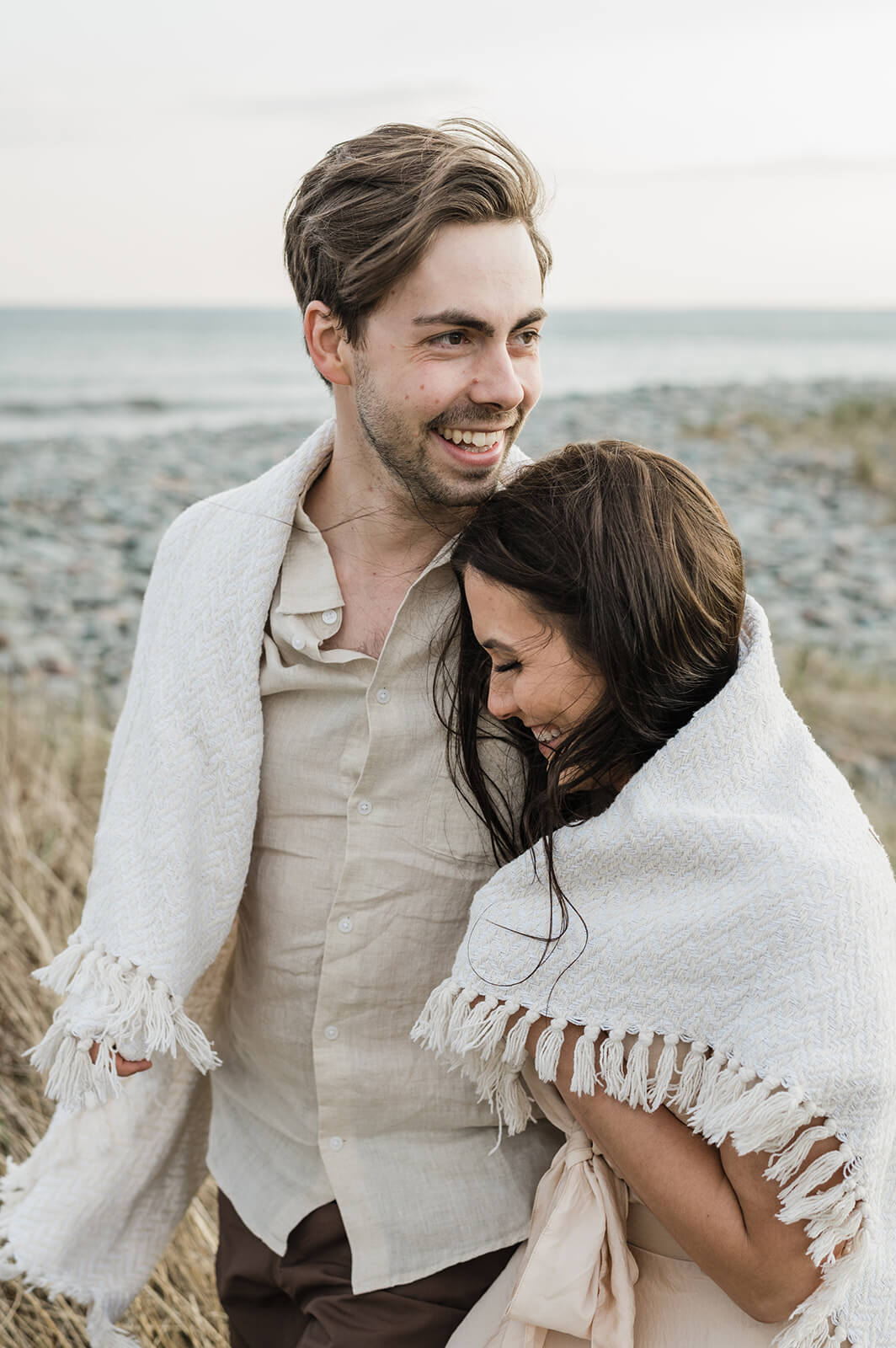 couple embrace at beach engagement session