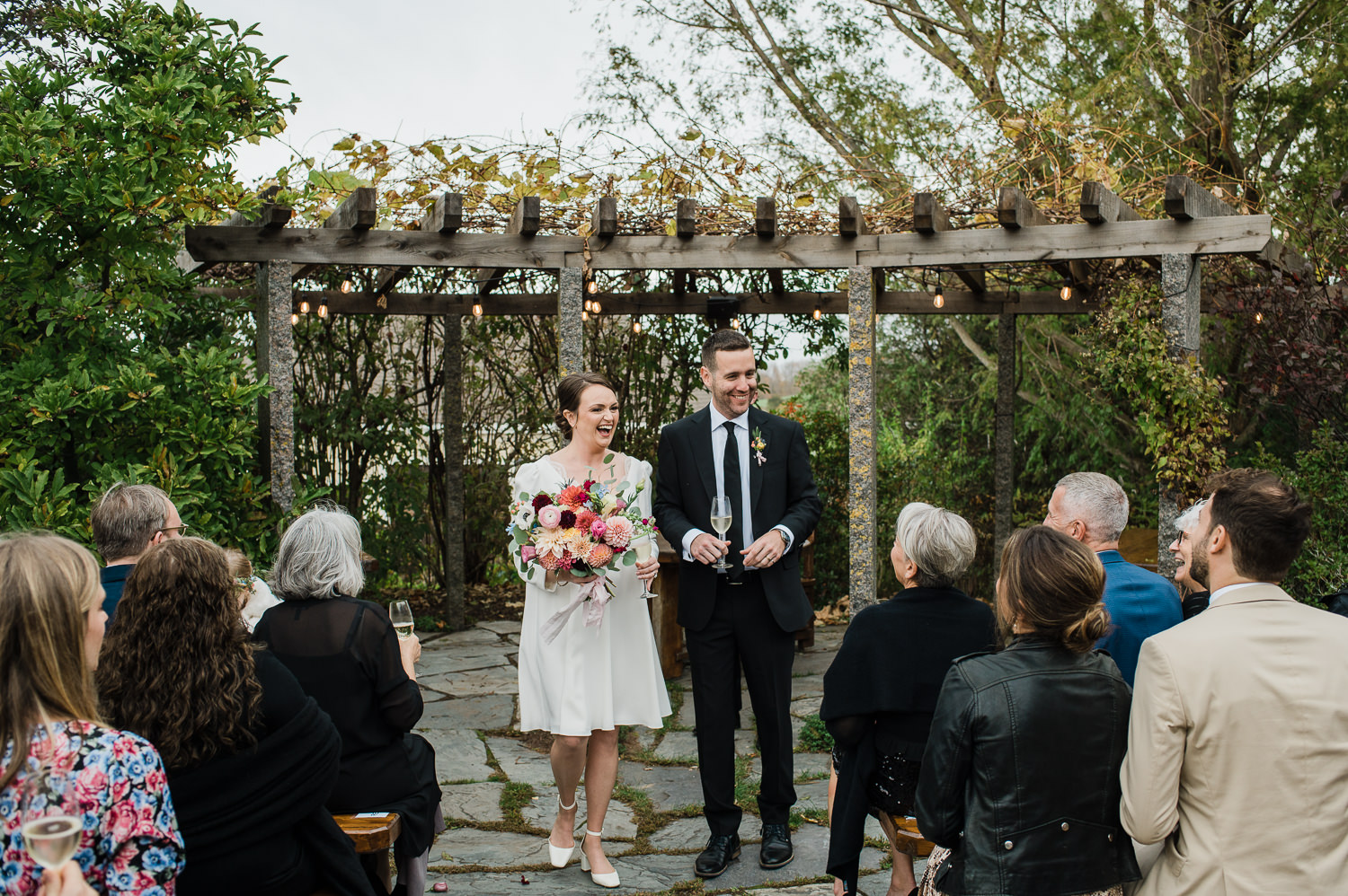 Bride and groom joyfully exit wedding ceremony held at Grand Pré Winery in Wolfville