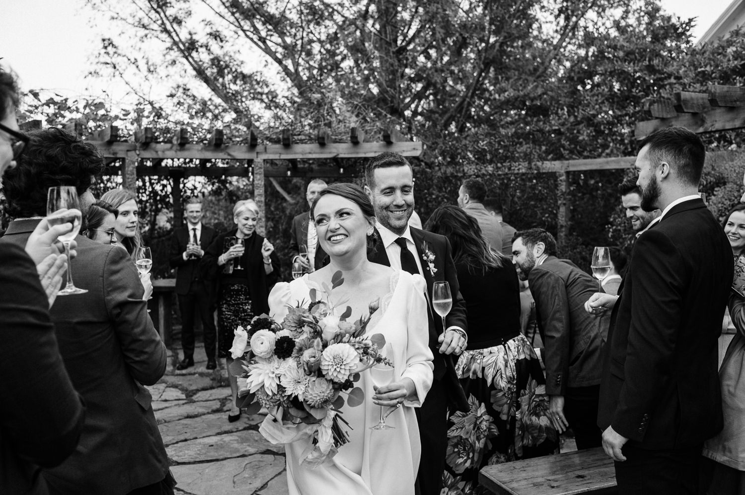 Bride and groom joyfully exit wedding ceremony held at Grand Pré Winery in Wolfville