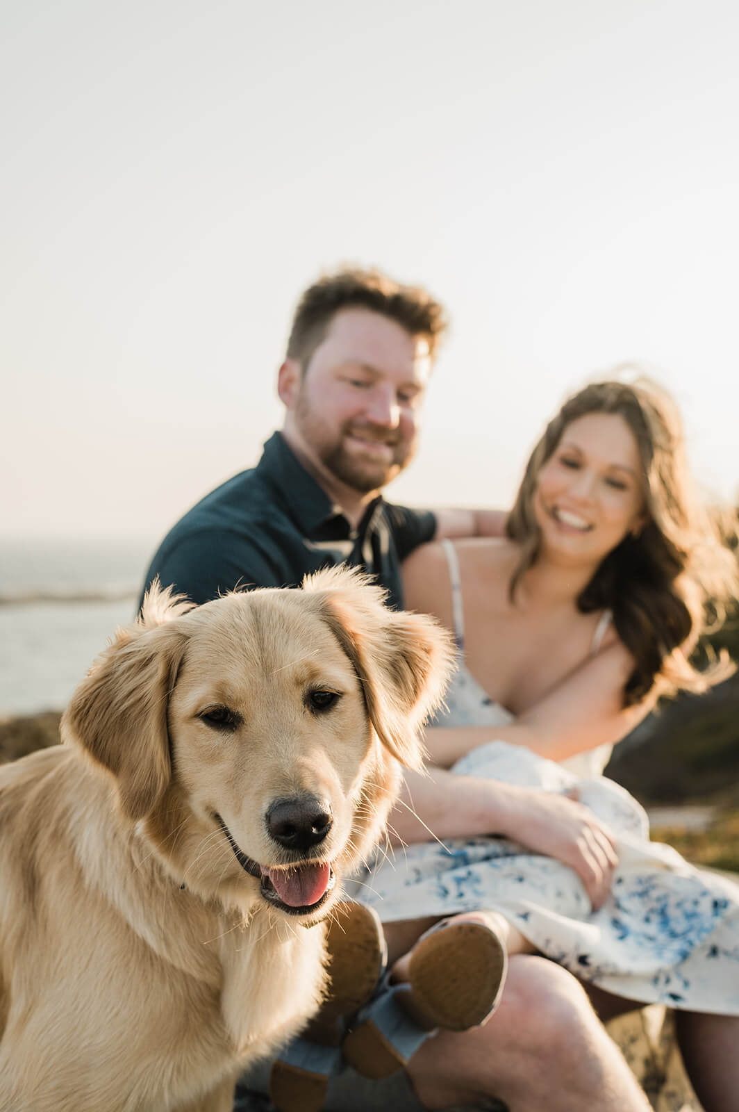 couple pose with their dog for engagement photos at Polly's Cove