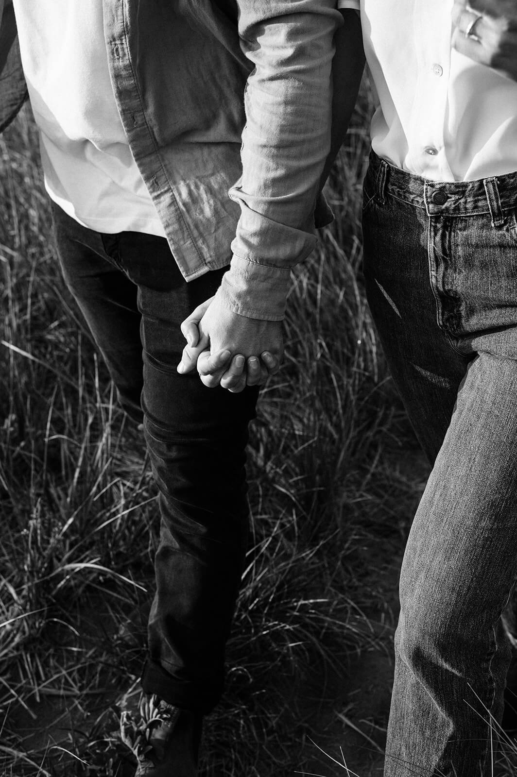 Couple holding hands on Rainbow Haven beach