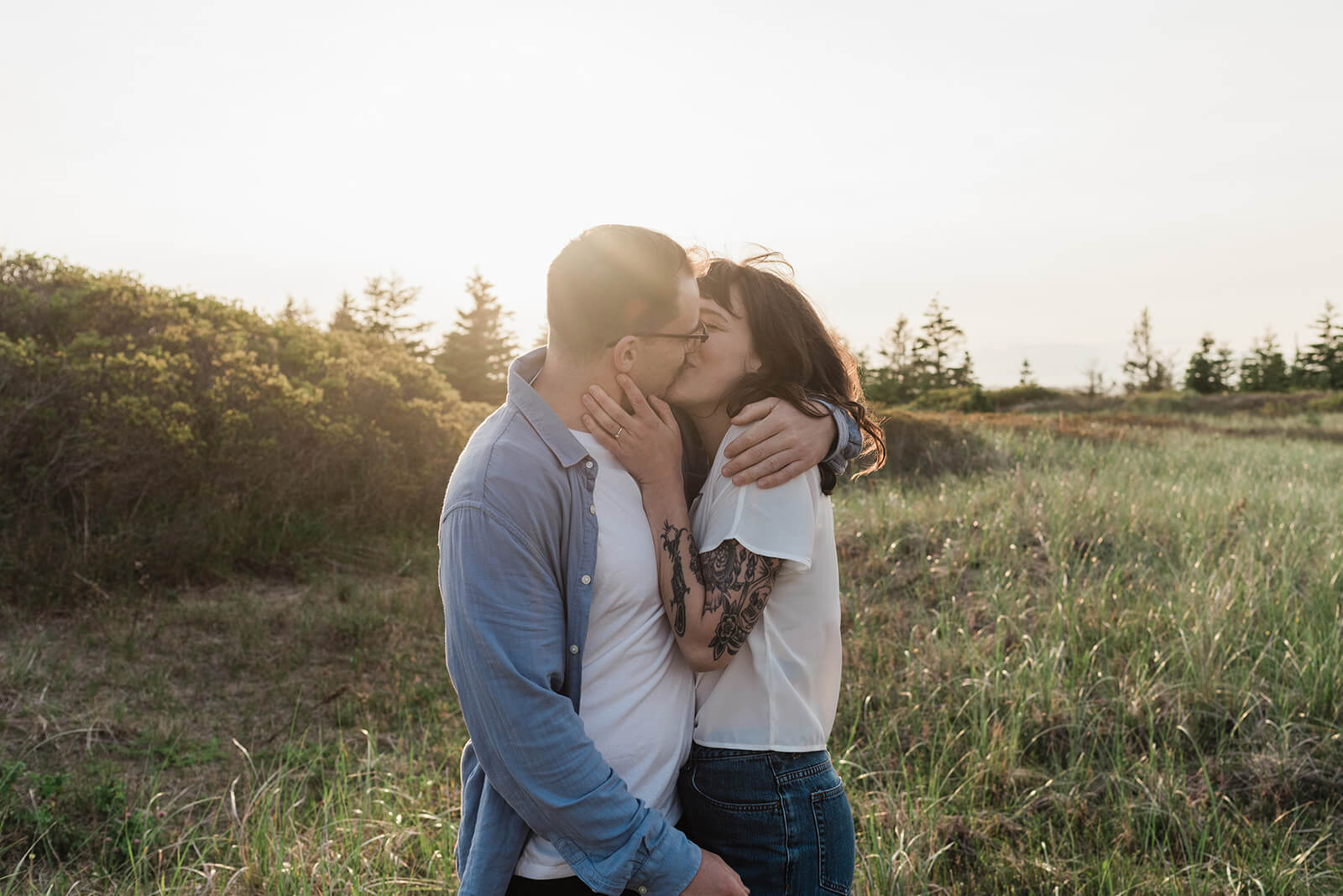 Couple embrace during engagement session on Rainbow Haven beach