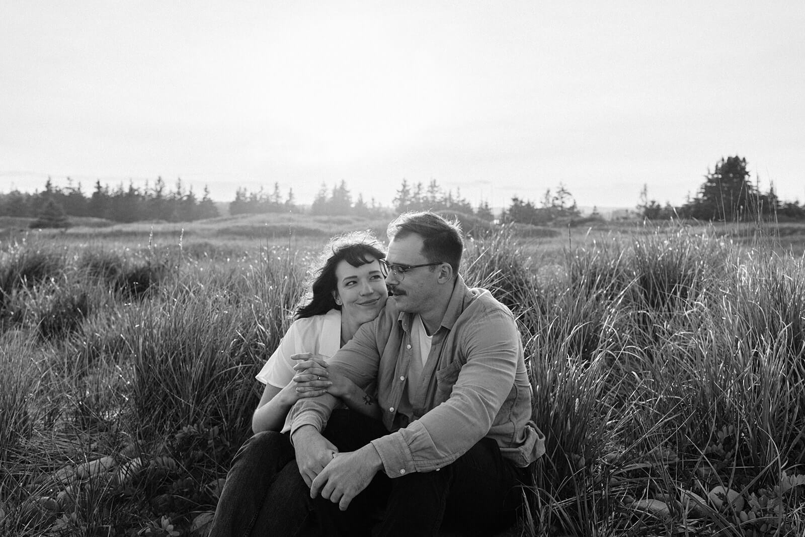 Couple embrace during engagement session on Rainbow Haven beach