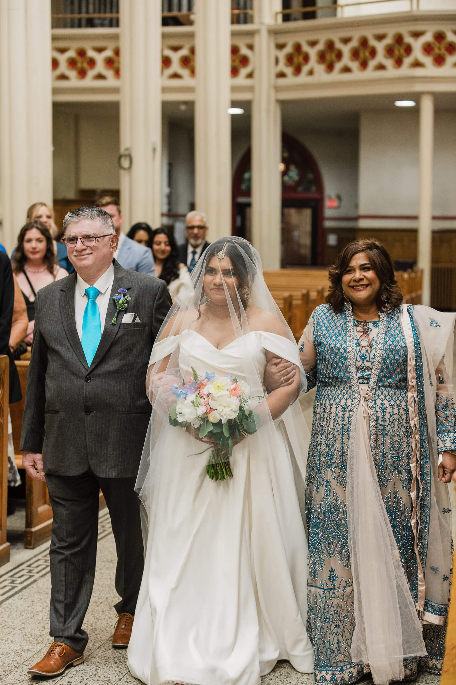 Bride walks down the aisle with parents at Saint Mary's Cathedral Basilica in Halifax