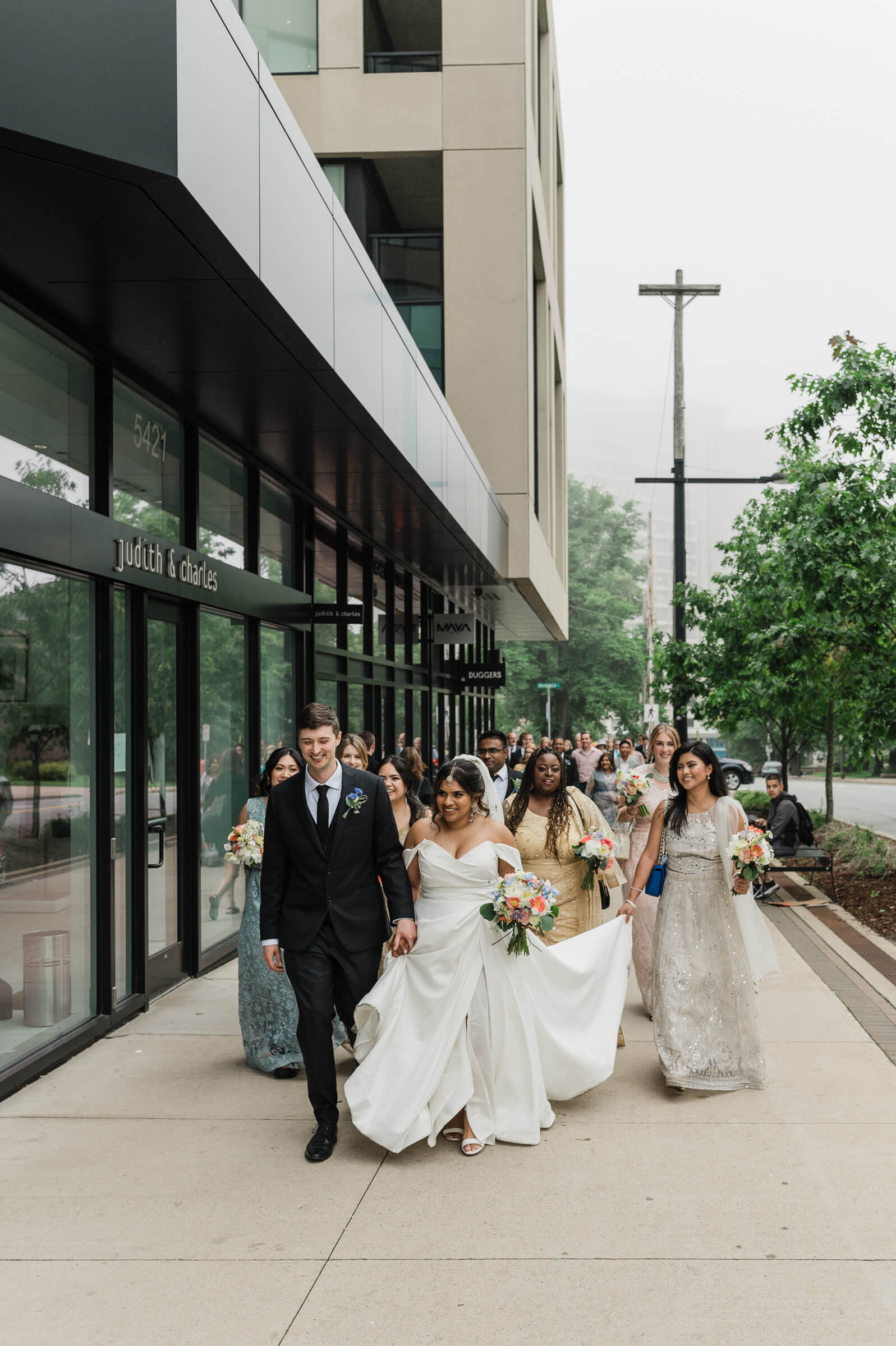 Wedding couple and friends walk on Spring Garden Road in Halifax