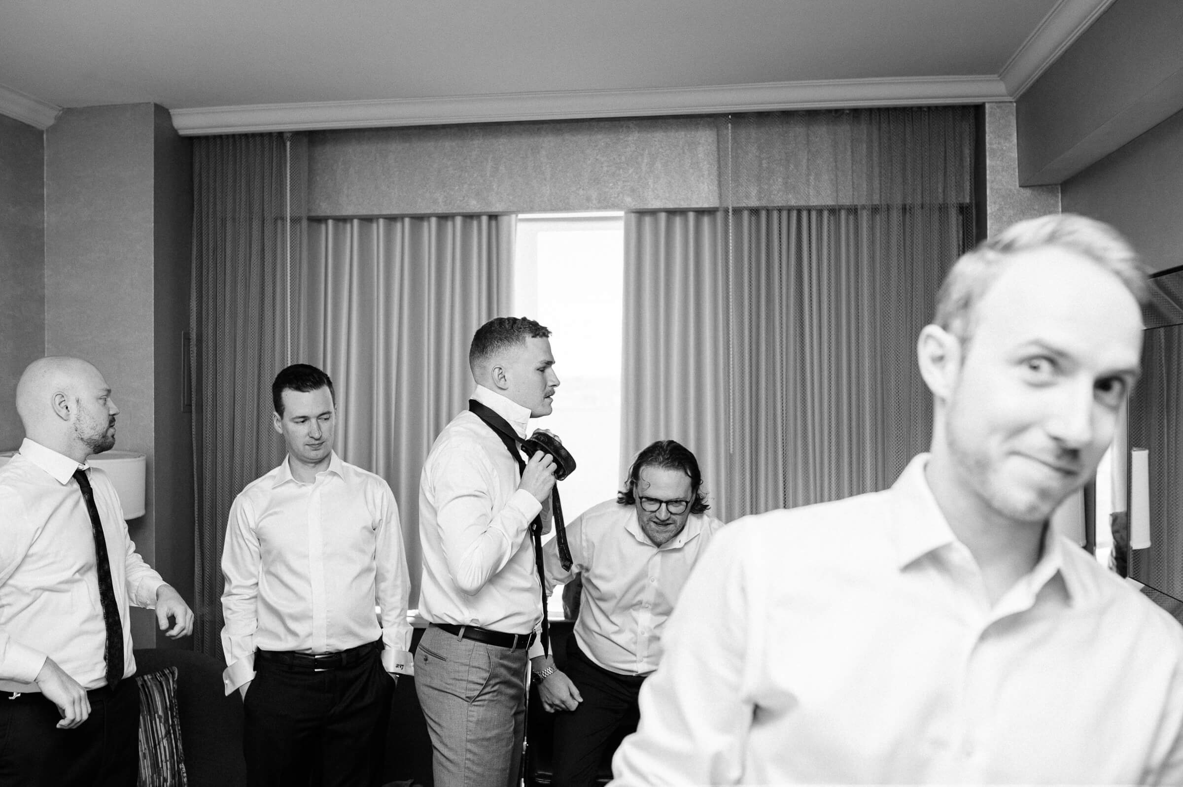 chaotic group of groomsmen get ready at westin nova scotia for wedding