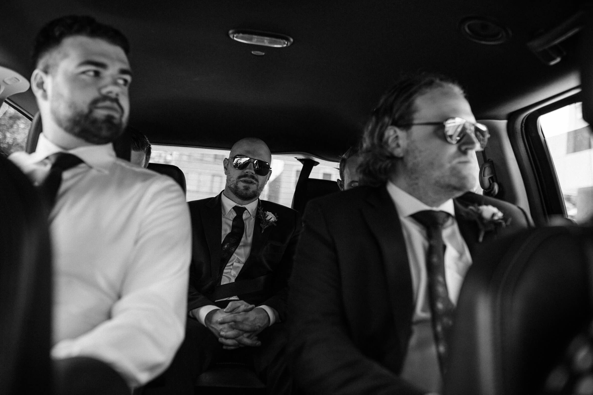 groomsmen in the back of car traveling to downtown halifax 