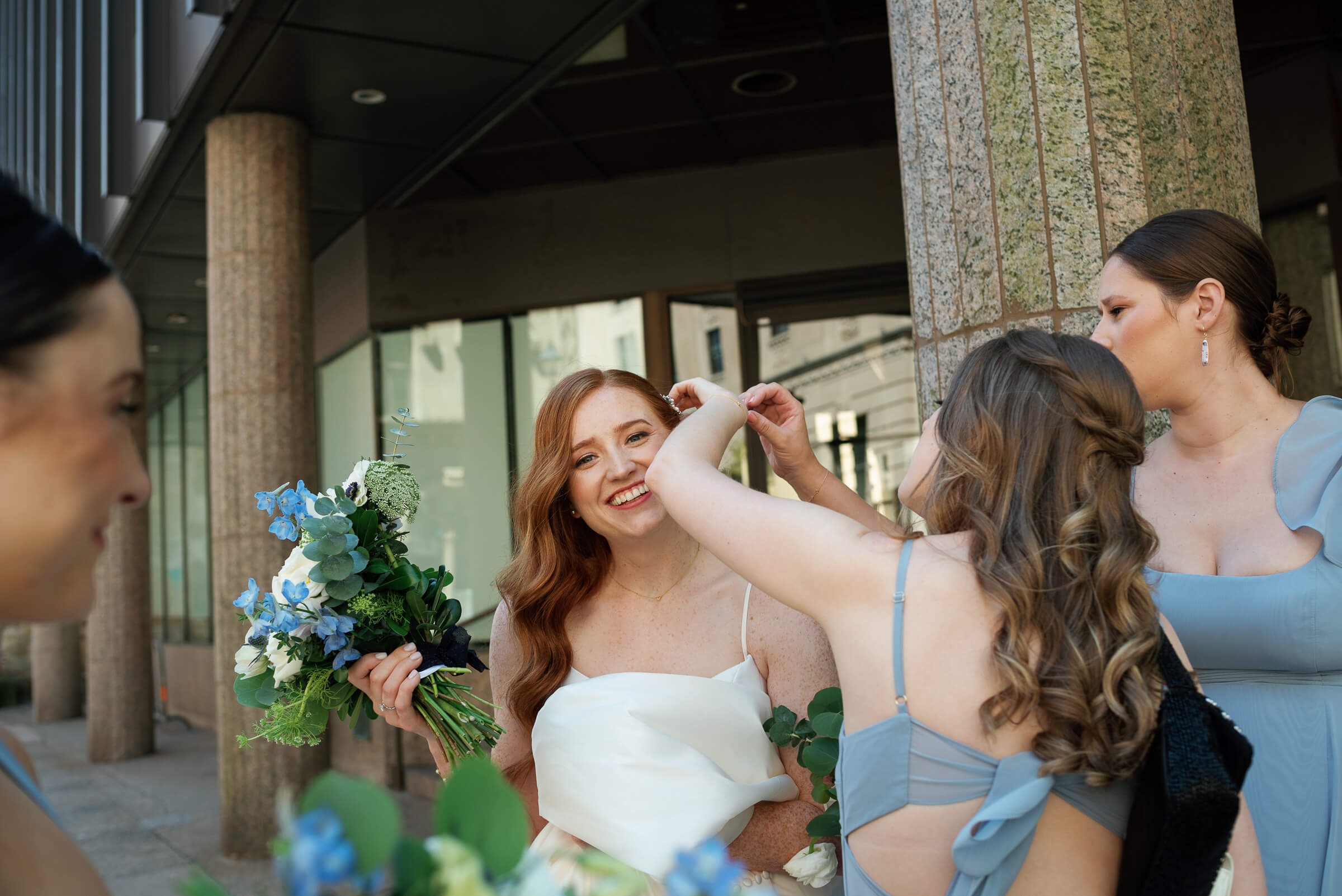 bridesmaids help bride fix her hair on halifax street