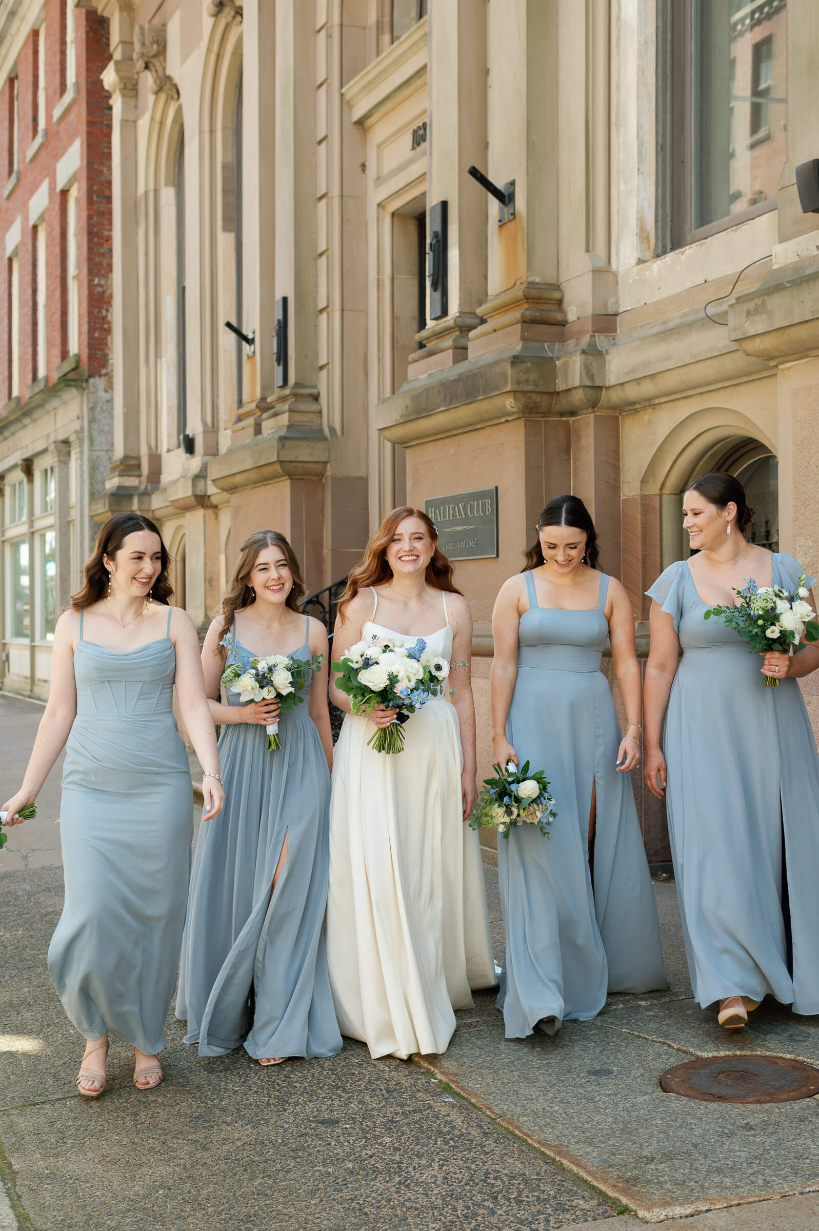 bride and bridesmaids walk in downtown halifax