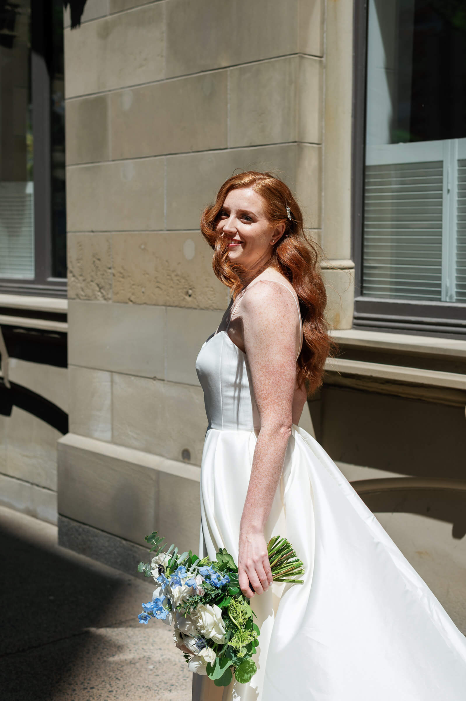 bride with beautiful red hair poses for photo on hollis street in halifax