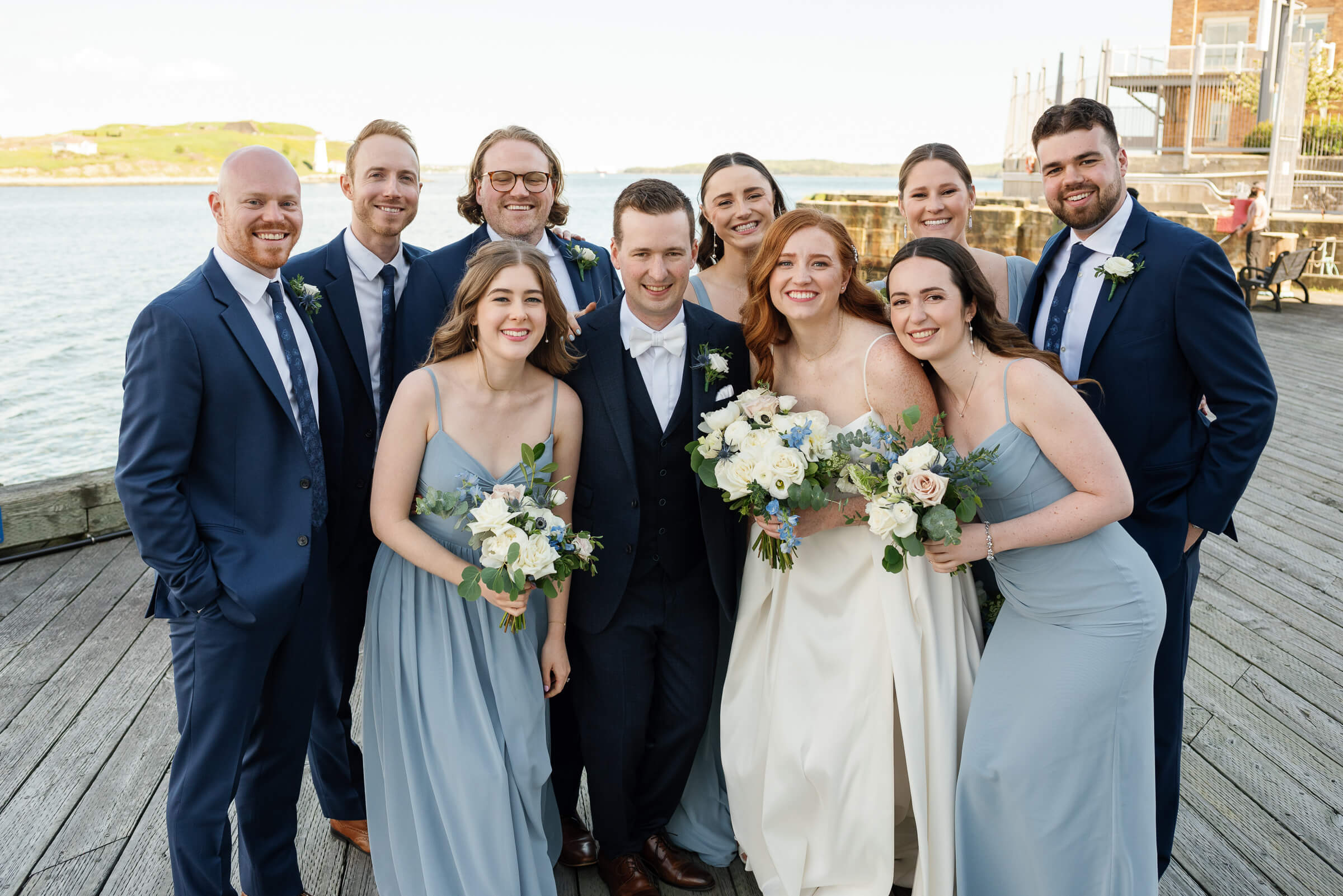 bridal party poses for group photo along the halifax waterfront