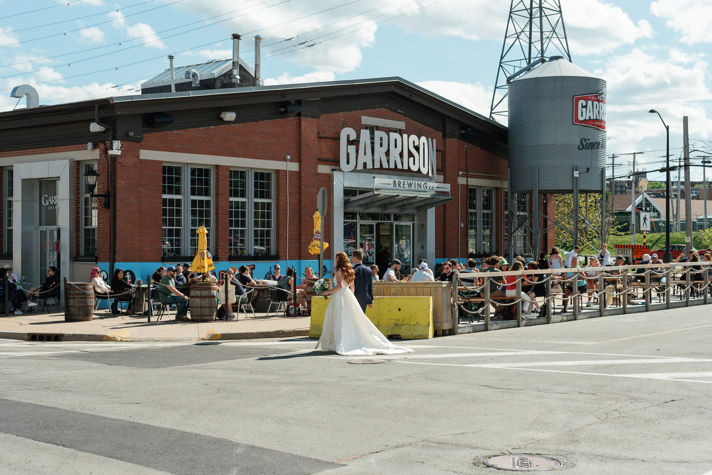 bride and groom cross the street near the garrison brewing co.