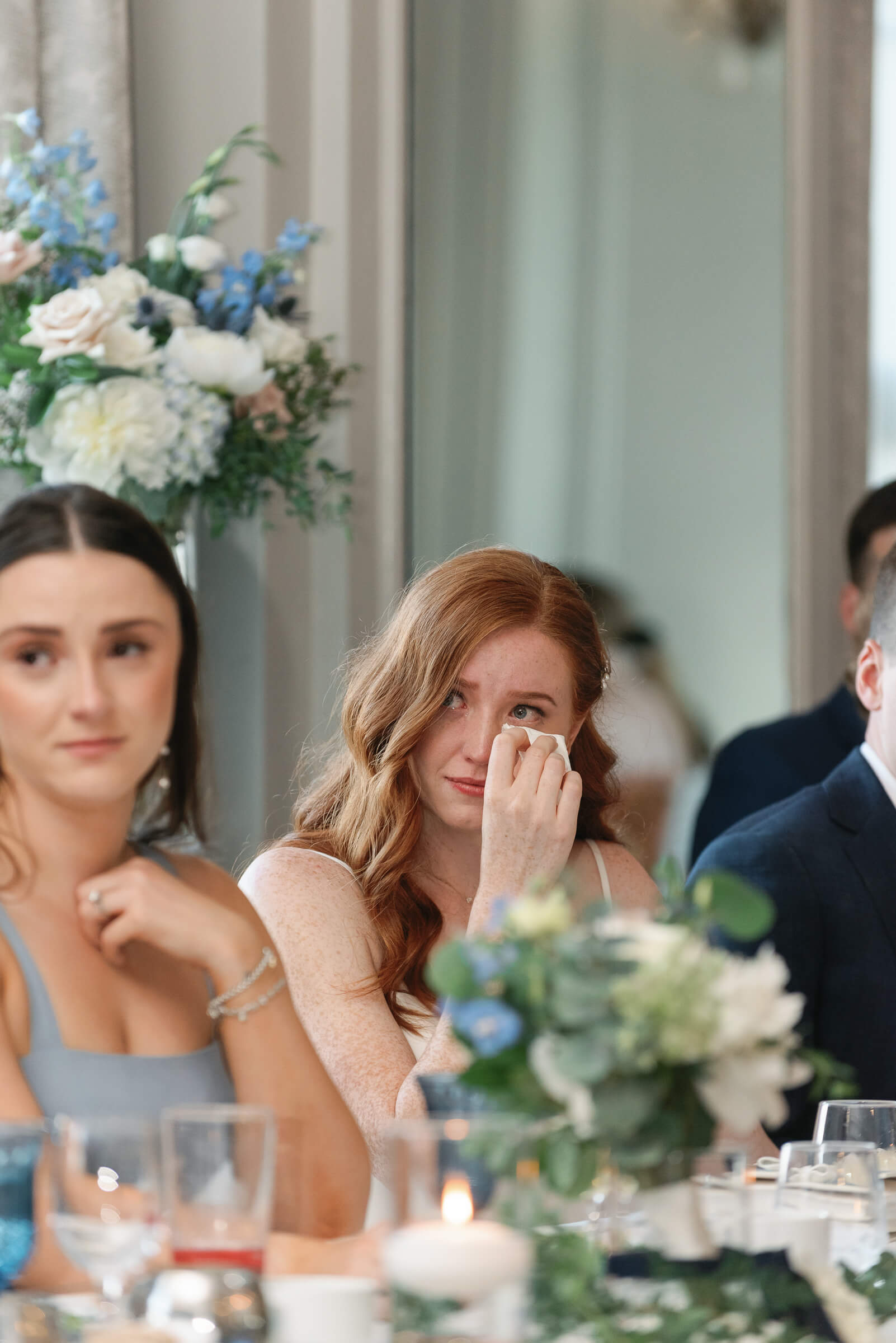 bride is emotional as she listen to speech at her wedding