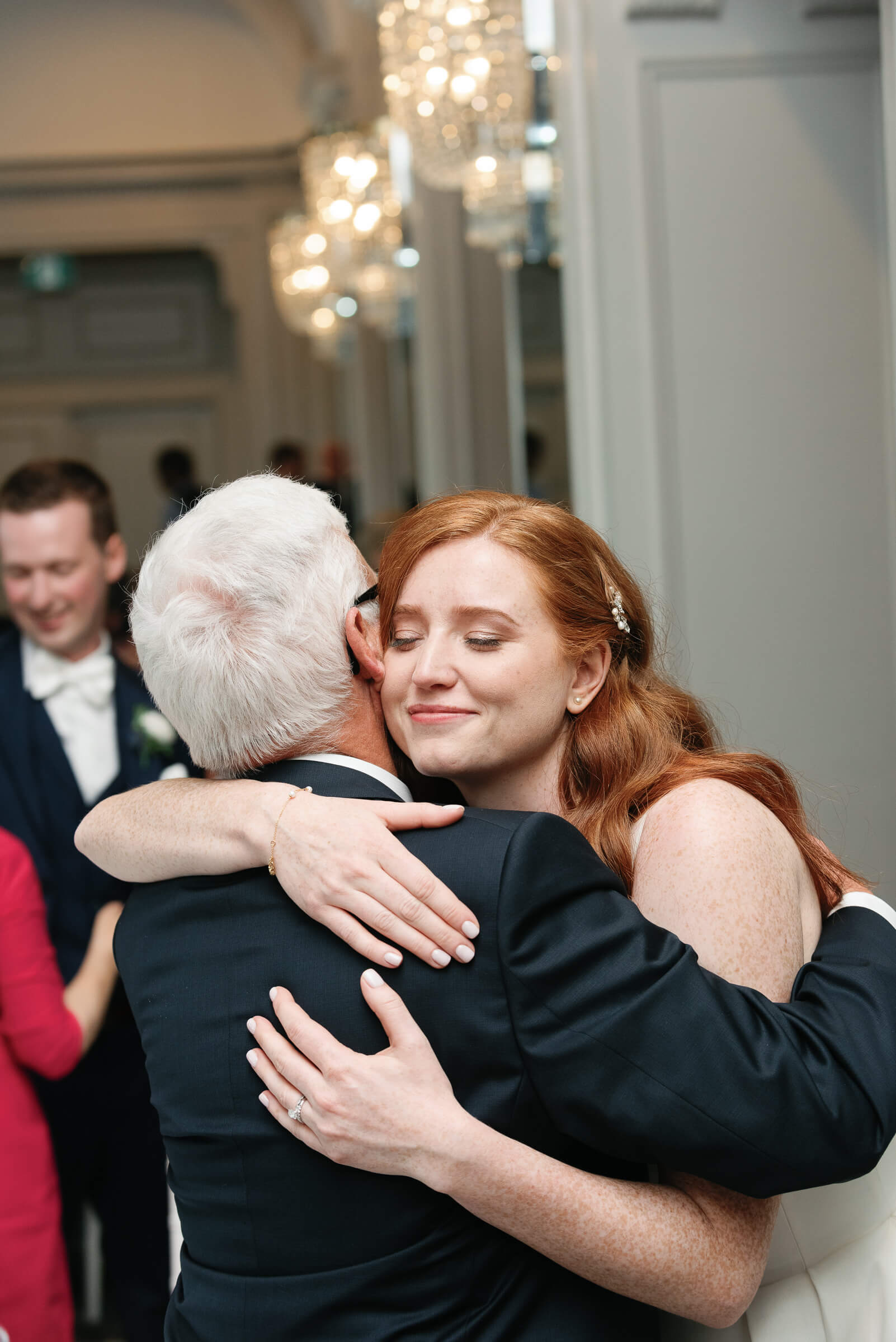 bride hugs grandfather at wedding reception